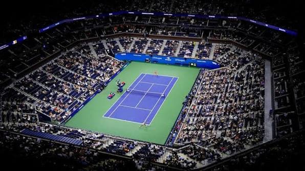 Arthur Ashe Stadium at night during a US Open match, seen from the upper bowl